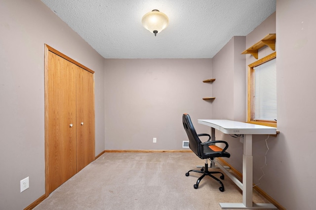 carpeted office featuring a textured ceiling