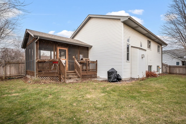 back of house featuring a lawn, a wooden deck, and a sunroom