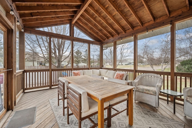 sunroom / solarium with vaulted ceiling with beams