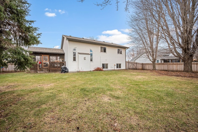 rear view of property featuring a wooden deck and a yard