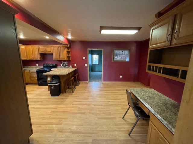 kitchen with electric range, light stone countertops, a breakfast bar area, a kitchen island, and light wood-type flooring