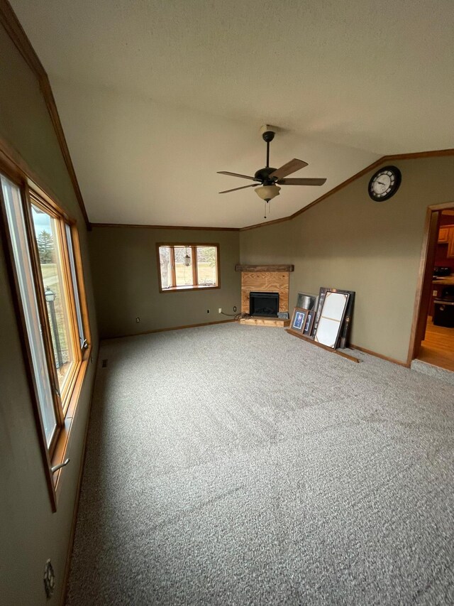 unfurnished living room with carpet flooring, vaulted ceiling, ceiling fan, and ornamental molding