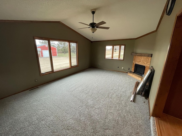 unfurnished living room with carpet flooring, a wealth of natural light, lofted ceiling, and ceiling fan