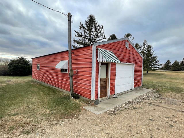 view of outbuilding with a garage and a yard