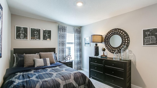 bedroom featuring carpet flooring and a textured ceiling