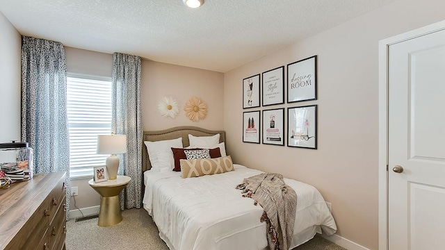 bedroom featuring a textured ceiling, carpet floors, and multiple windows