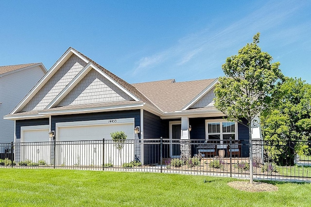 craftsman inspired home featuring a garage and a front lawn