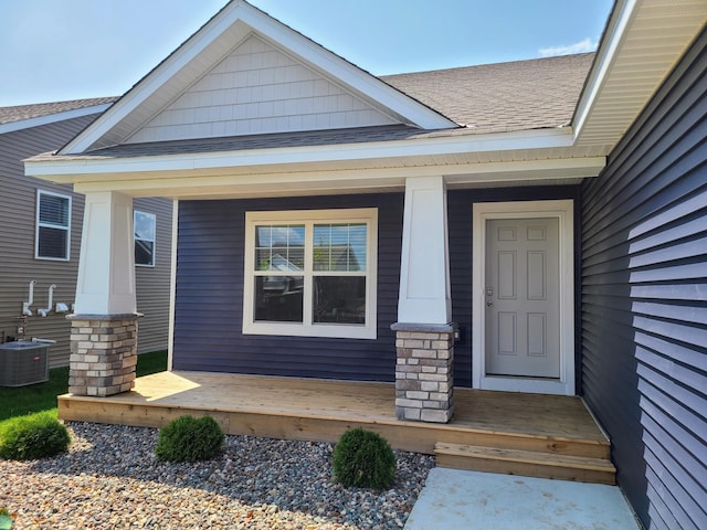 doorway to property with a porch and central AC unit