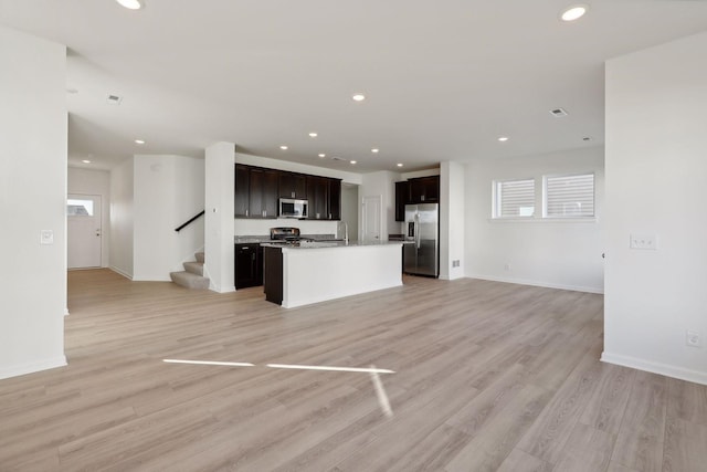 kitchen featuring a kitchen island, stainless steel appliances, and light wood-type flooring