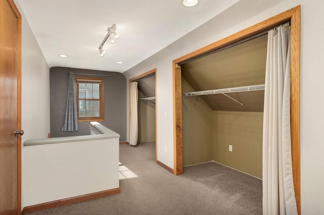 unfurnished bedroom featuring lofted ceiling, carpet floors, recessed lighting, and track lighting