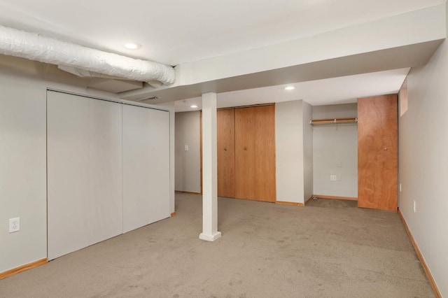 finished basement featuring light carpet, baseboards, and recessed lighting