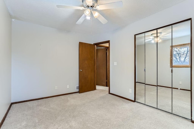 unfurnished bedroom featuring ceiling fan, light colored carpet, and a closet