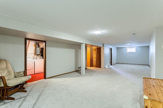 basement with carpet floors, washer and dryer, and electric panel