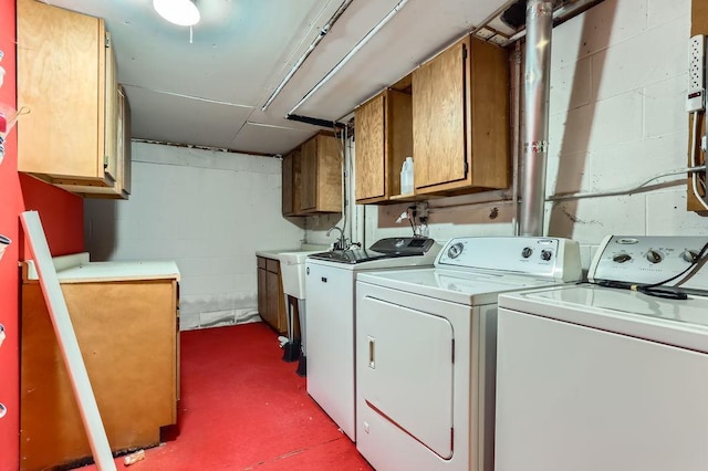 clothes washing area featuring cabinets and washing machine and clothes dryer