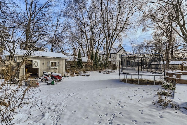 yard covered in snow with a trampoline