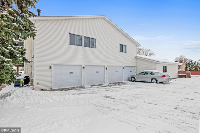 view of snowy exterior with a garage