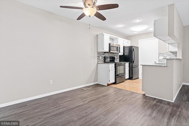 kitchen featuring black appliances, white cabinets, light wood-type flooring, and tasteful backsplash