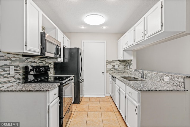 kitchen with light stone countertops, sink, stainless steel appliances, light tile patterned floors, and white cabinets