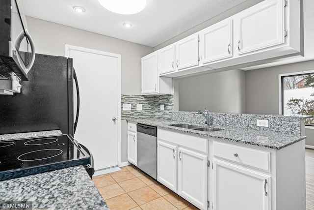 kitchen featuring dishwasher, range, black fridge, sink, and white cabinetry