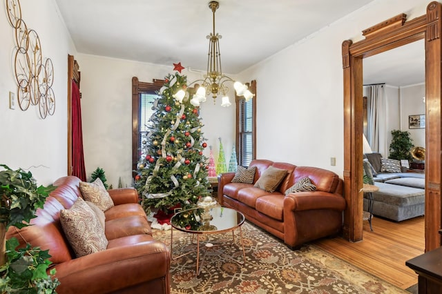 living room with crown molding, a chandelier, and hardwood / wood-style flooring