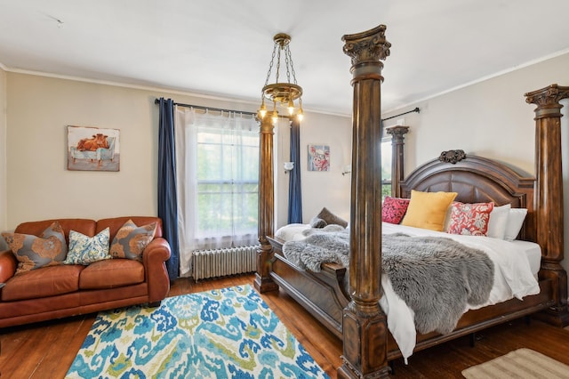 bedroom with dark hardwood / wood-style floors, ornamental molding, and radiator