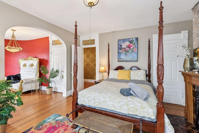 bedroom featuring wood-type flooring and a fireplace