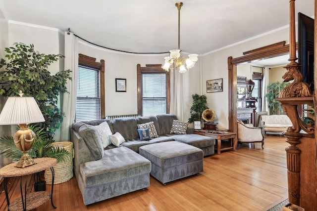 living room with hardwood / wood-style flooring, a notable chandelier, and crown molding