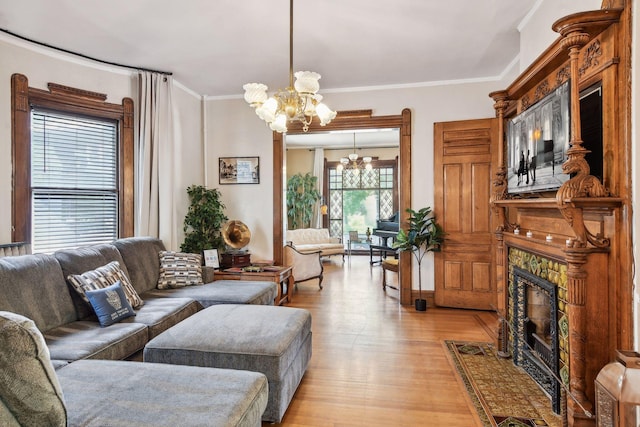 living room with ornamental molding, light hardwood / wood-style floors, and an inviting chandelier