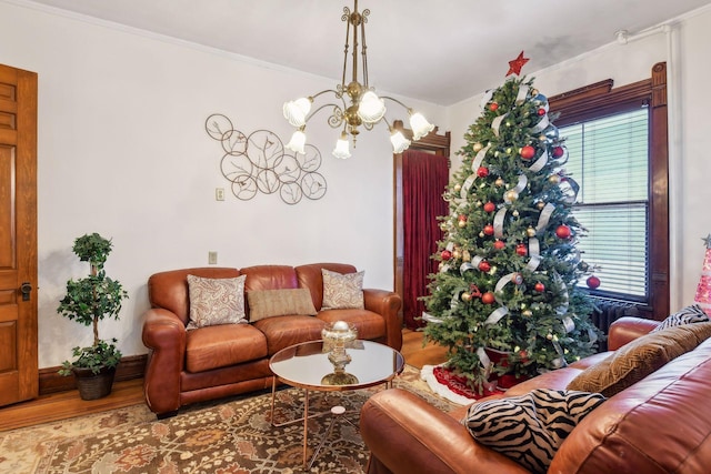 living room featuring a chandelier, hardwood / wood-style flooring, crown molding, and a healthy amount of sunlight