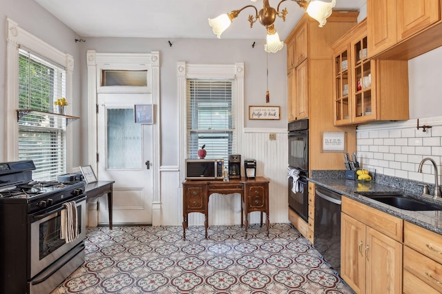 kitchen featuring decorative backsplash, sink, black appliances, dark stone countertops, and hanging light fixtures