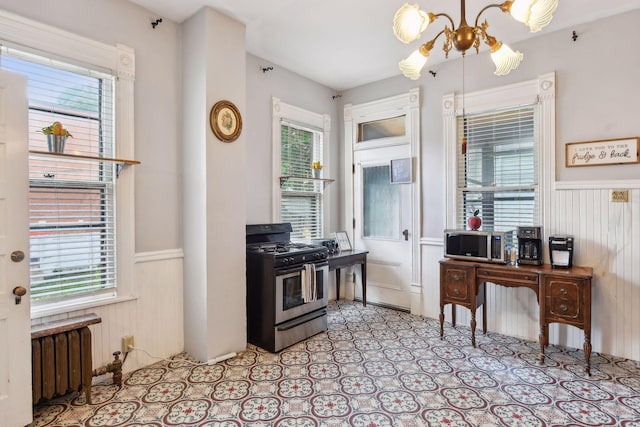 kitchen with appliances with stainless steel finishes, plenty of natural light, and radiator