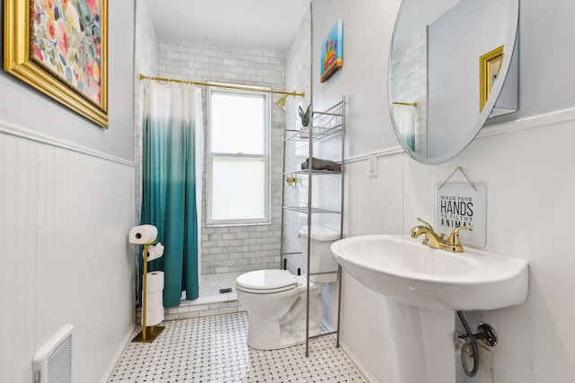 bathroom featuring curtained shower, sink, and toilet