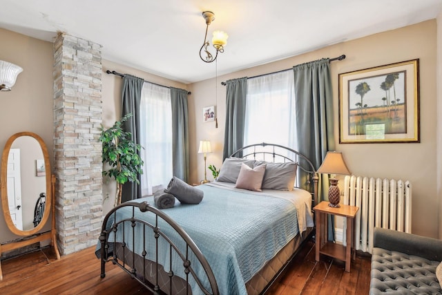 bedroom with radiator and dark hardwood / wood-style flooring