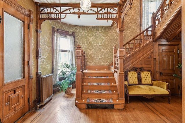 stairs featuring hardwood / wood-style floors and radiator