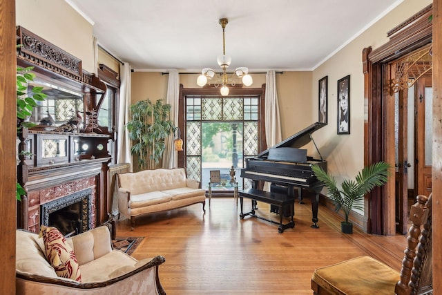 living area with light wood-type flooring, ornamental molding, a high end fireplace, and a chandelier