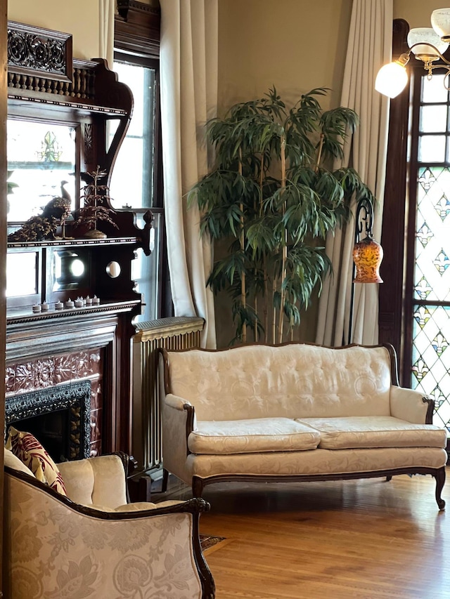 living area with an inviting chandelier, wood finished floors, and a healthy amount of sunlight