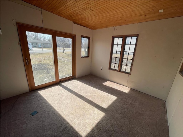 carpeted spare room with wood ceiling