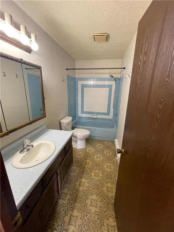 full bathroom featuring vanity, bathtub / shower combination, a textured ceiling, and toilet