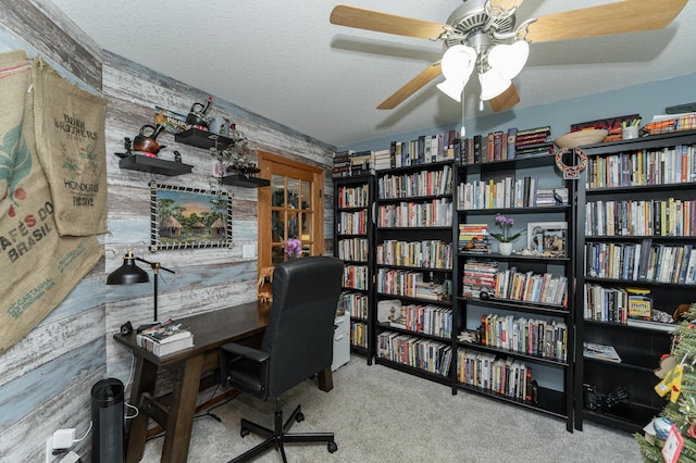 carpeted home office featuring ceiling fan and a textured ceiling