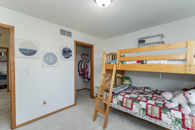 carpeted bedroom with a spacious closet and a closet