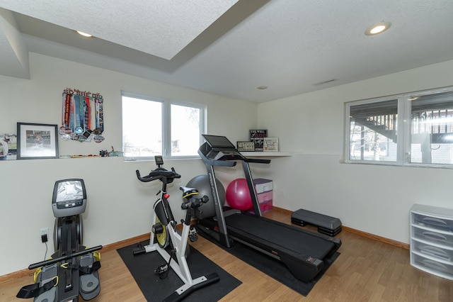 workout area featuring hardwood / wood-style flooring and a textured ceiling