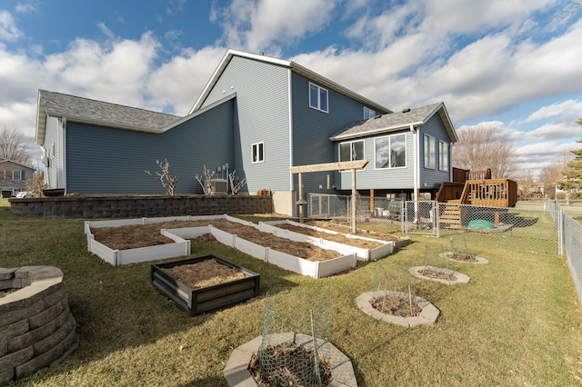 back of house with an outdoor fire pit, a deck, and a lawn