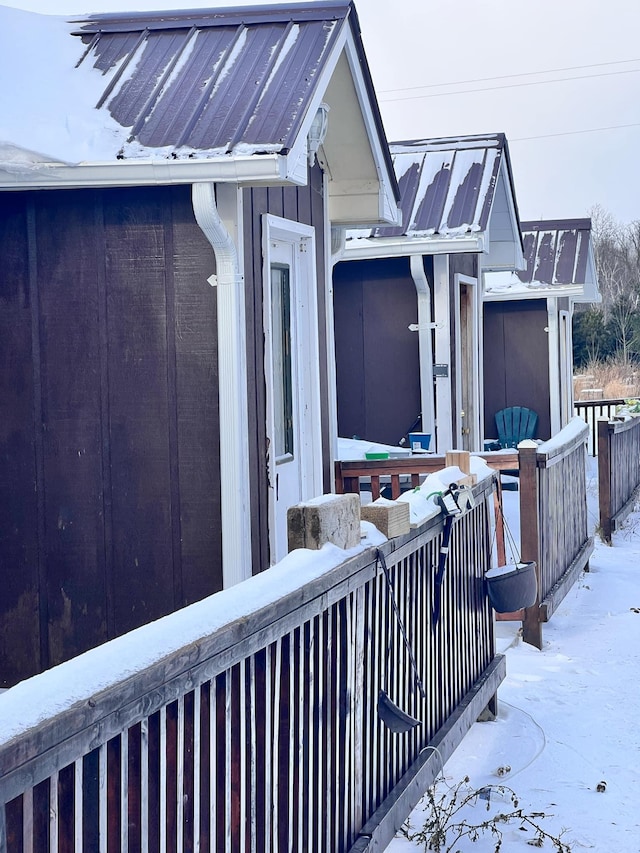 view of snow covered exterior with a deck