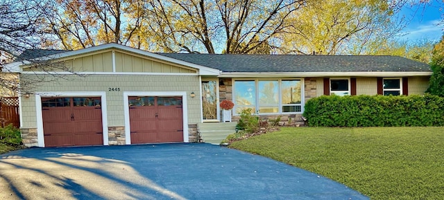 ranch-style home with a garage and a front lawn