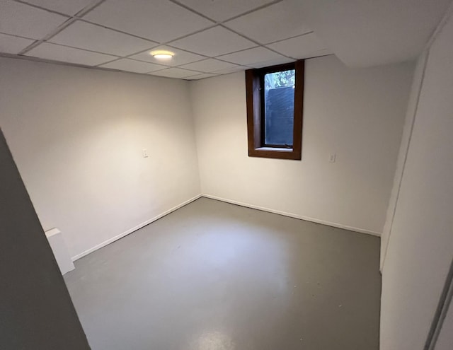 unfurnished room with a paneled ceiling and concrete floors