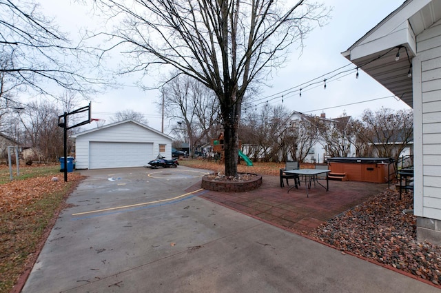 view of yard with a patio area, a garage, an outbuilding, and a hot tub