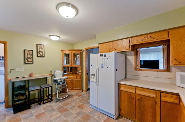 kitchen featuring decorative backsplash and white appliances