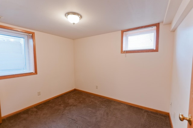 unfurnished room featuring dark carpet