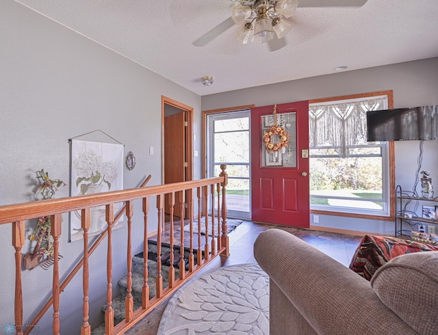 interior space featuring ceiling fan and a textured ceiling