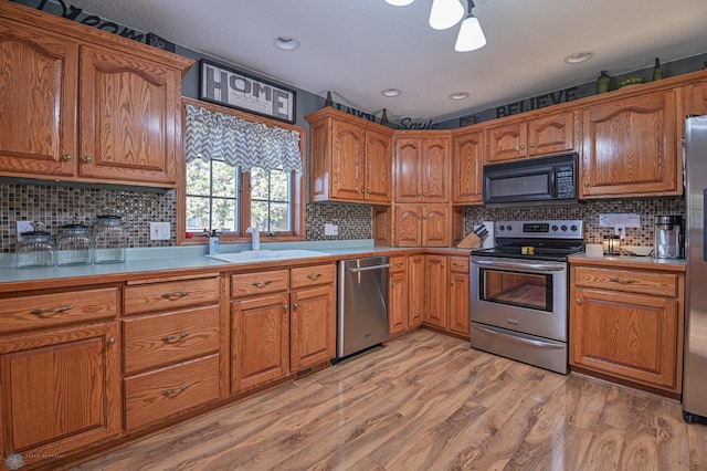 429 Bridge Ave, Warren, MN 56762 - kitchen with stainless steel appliances, brown cabinetry, decorative backsplash, and recessed lighting
